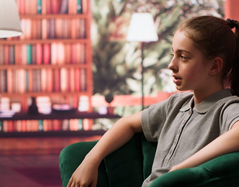 Teen girl in a confidential therapy session discussing personal challenges Teen girl in a confidential therapy session discussing personal challenges like anxiety, social issues and depression. Psychologist supports her emotional well being and mental resilience. Camera A.